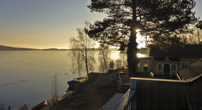 Det här är vad min husse kan se. Visserligen skymmer tallen solen så här års, men man kan ju ana den. Det är fortfarande is på sjön.